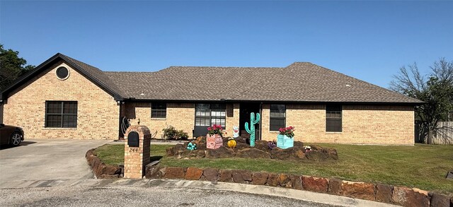 ranch-style home featuring a front yard, a shingled roof, and brick siding
