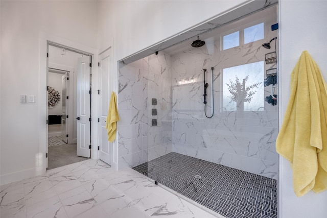 bathroom with marble finish floor, baseboards, and a marble finish shower