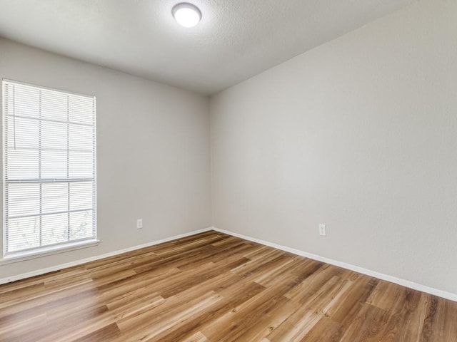 unfurnished room with light wood finished floors and baseboards