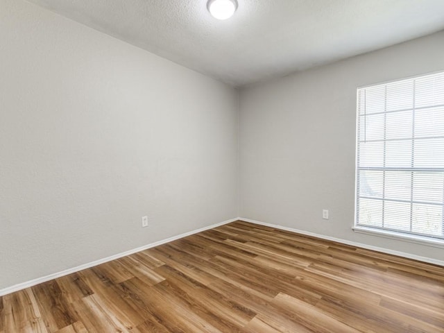 unfurnished room featuring wood finished floors and baseboards