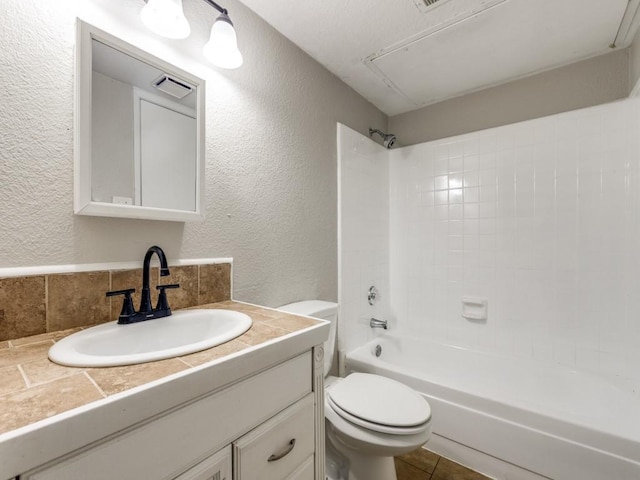 bathroom with toilet, tub / shower combination, a textured wall, vanity, and tasteful backsplash