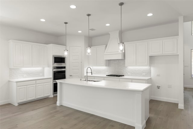 3811 Lochwood Dr, Rowlett, TX 75088 - kitchen featuring custom exhaust hood, appliances with stainless steel finishes, decorative backsplash, light wood-type flooring, and white cabinetry