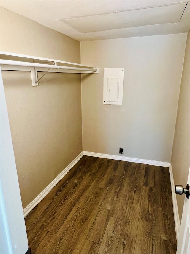 clothes washing area with laundry area, wood finished floors, hookup for an electric dryer, electric panel, and baseboards