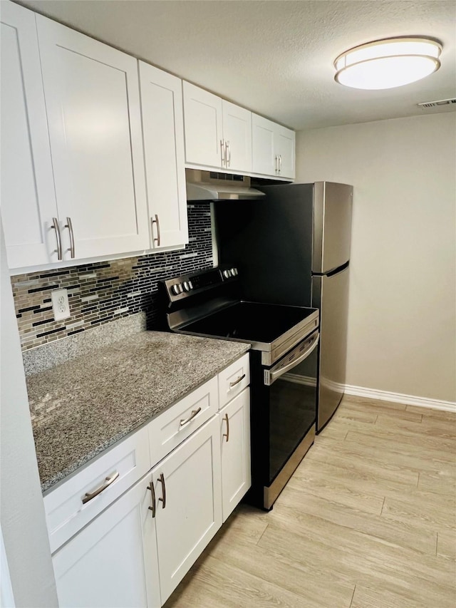 kitchen featuring white cabinets, stainless steel range with electric cooktop, under cabinet range hood, visible vents, and tasteful backsplash