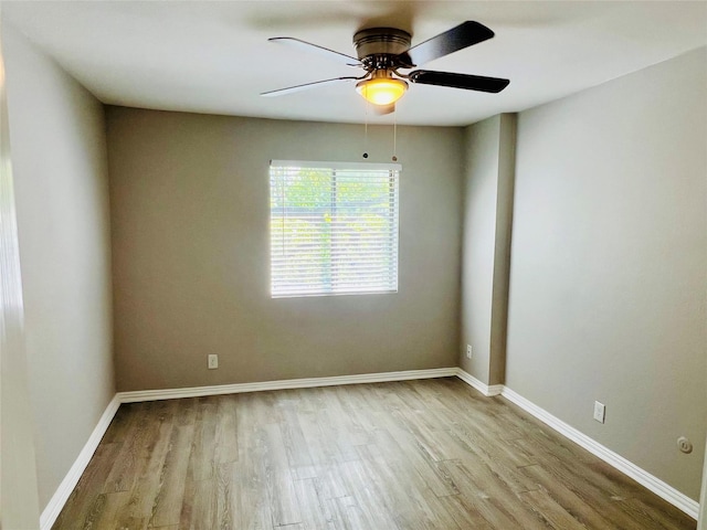 unfurnished room with baseboards, a ceiling fan, and wood finished floors