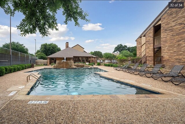 community pool with fence and a patio