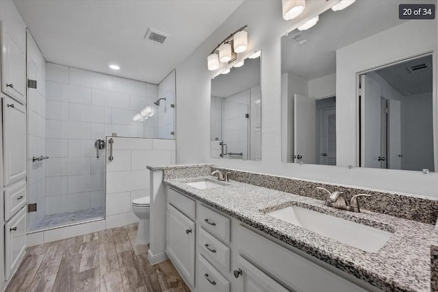 bathroom featuring visible vents, a sink, a shower stall, and toilet