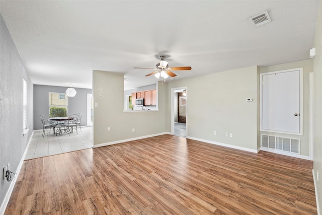 117 Independence Ave, Venus, TX 76084 - unfurnished living room with light wood-type flooring, ceiling fan, and baseboards