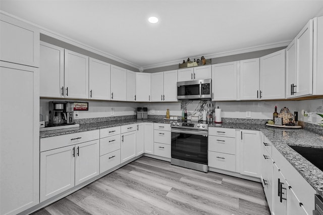 1210 Carla Dr, Denison, TX 75020 - kitchen featuring appliances with stainless steel finishes, crown molding, light wood-type flooring, dark stone counters, and white cabinetry