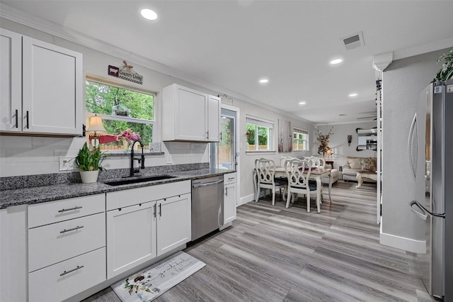 1210 Carla Dr, Denison, TX 75020 - kitchen with appliances with stainless steel finishes, a sink, crown molding, white cabinetry, and dark stone countertops