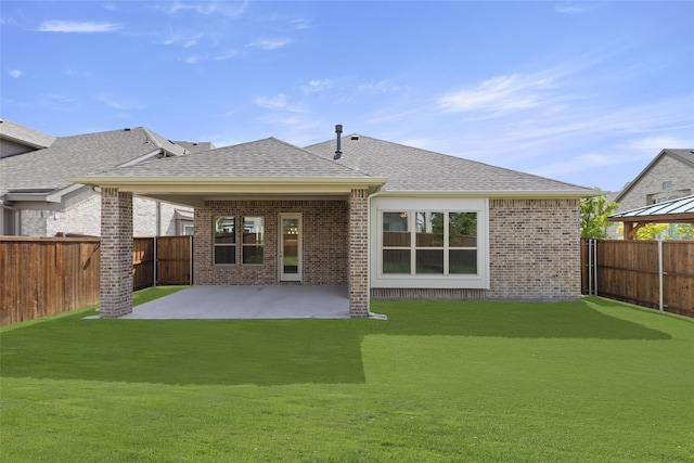 back of house with a patio area, a fenced backyard, brick siding, and a yard