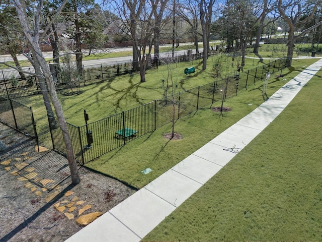 view of home's community with a yard and fence
