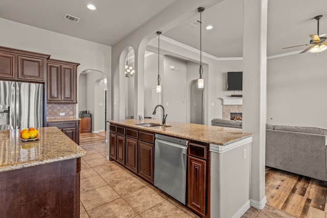 1109 Mount Ln, Rhome, TX 76078 - kitchen with appliances with stainless steel finishes, a sink, arched walkways, ceiling fan, and open floor plan