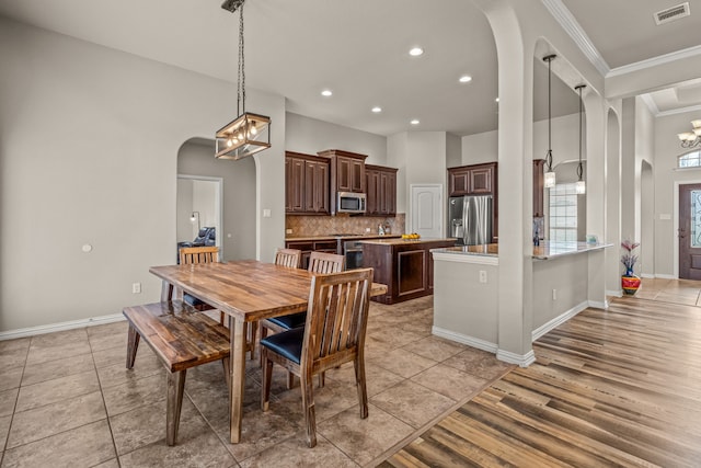 1109 Mount Ln, Rhome, TX 76078 - dining space with arched walkways, ornamental molding, recessed lighting, a chandelier, and baseboards