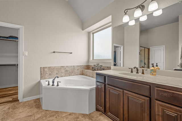 1109 Mount Ln, Rhome, TX 76078 - bathroom with vanity, a bath, a spacious closet, a stall shower, and vaulted ceiling