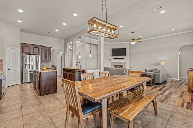 1109 Mount Ln, Rhome, TX 76078 - dining area featuring arched walkways, ceiling fan, a tile fireplace, recessed lighting, and light tile patterned flooring