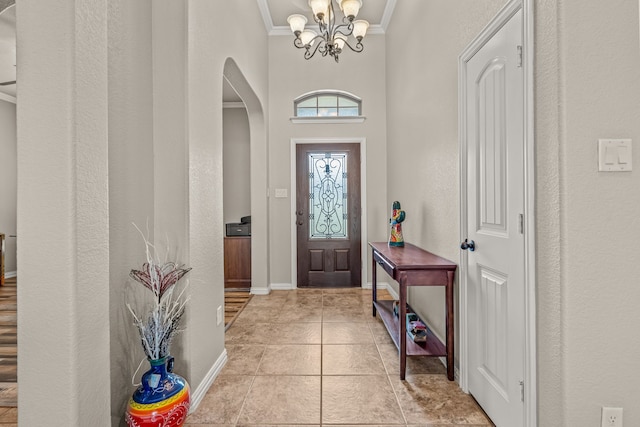 1109 Mount Ln, Rhome, TX 76078 - foyer entrance with arched walkways, crown molding, a chandelier, light tile patterned floors, and a textured wall