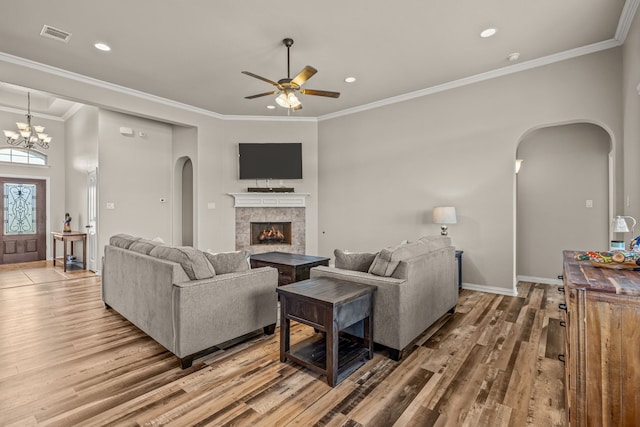 1109 Mount Ln, Rhome, TX 76078 - living area featuring arched walkways, wood finished floors, a ceiling fan, a fireplace, and crown molding