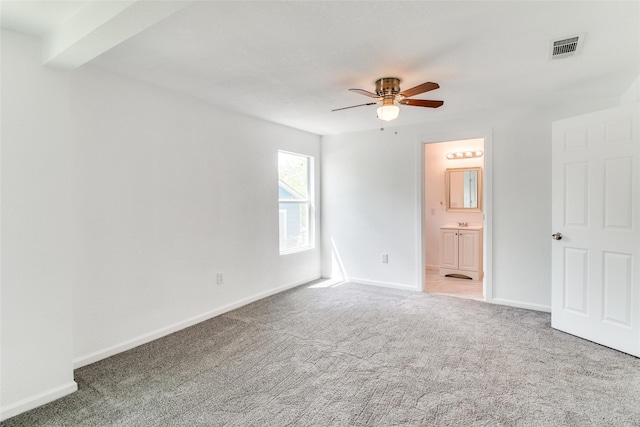 309 W Monterey St, Denison, TX 75020 - unfurnished bedroom featuring baseboards, ensuite bath, a ceiling fan, carpet floors, and visible vents