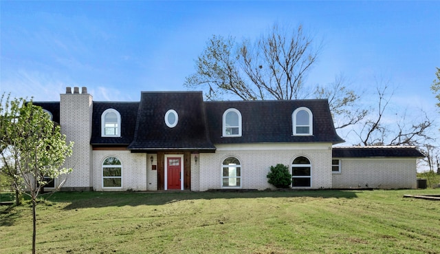 view of front of house featuring roof with shingles, mansard roof, a front lawn, and brick siding