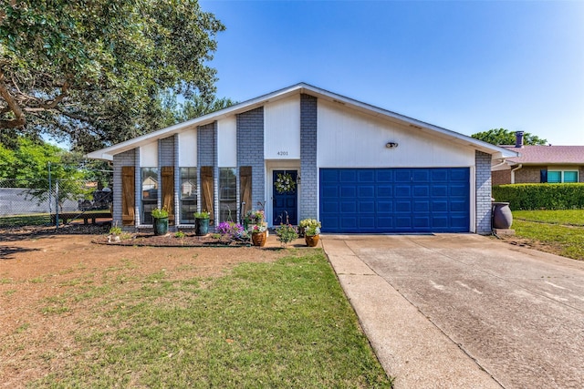 view of front of home featuring brick siding, fence, a front lawn, and concrete driveway