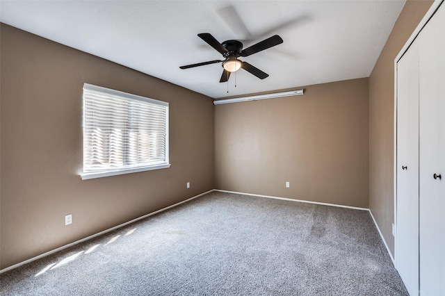 unfurnished bedroom featuring baseboards, ceiling fan, a closet, and carpet