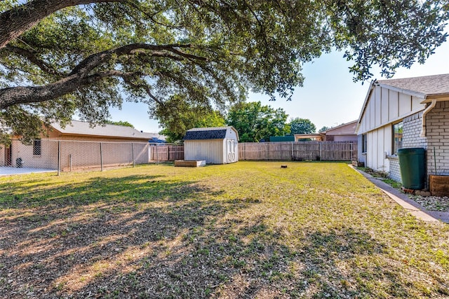 view of yard featuring a storage unit, a fenced backyard, and an outdoor structure
