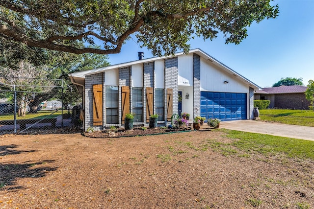 view of front of property featuring fence, concrete driveway, a front yard, and a garage