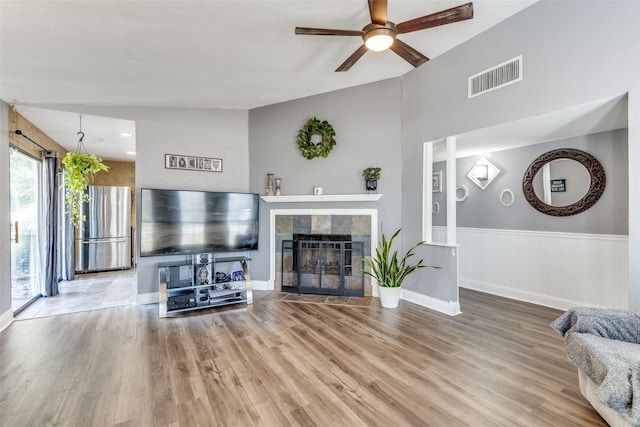 living area featuring visible vents, ceiling fan, wood finished floors, and a fireplace