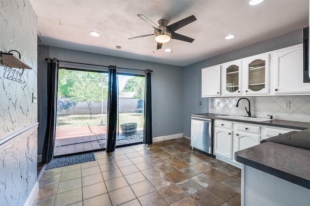 kitchen featuring white cabinetry, dark countertops, dishwasher, a ceiling fan, and backsplash
