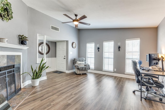 office with a fireplace, wood finished floors, visible vents, and a ceiling fan