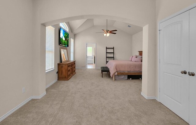 carpeted bedroom with arched walkways, baseboards, a ceiling fan, and lofted ceiling