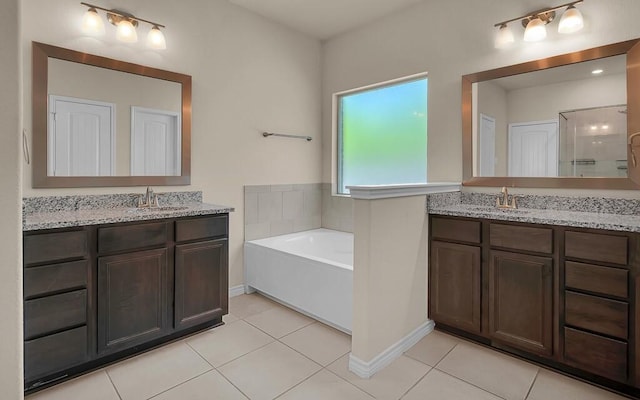 bathroom featuring tile patterned floors, a sink, and two vanities