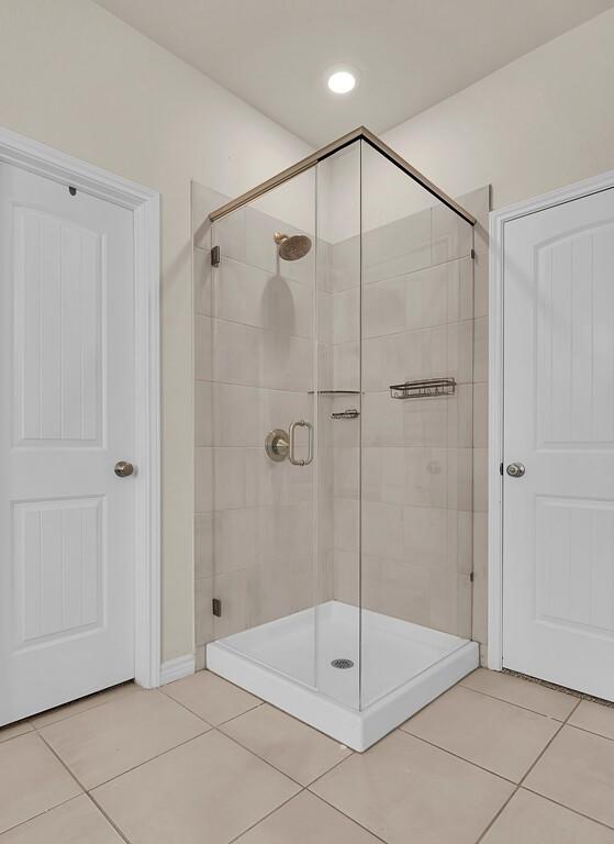 full bathroom featuring a shower stall and tile patterned flooring