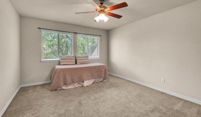 carpeted bedroom with baseboards and a ceiling fan