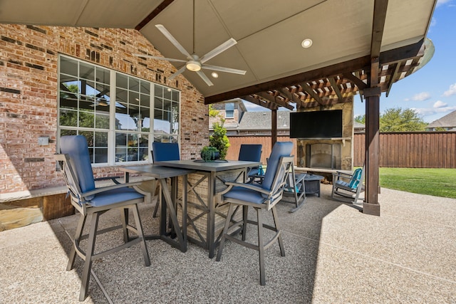9892 Ranchero Dr, Frisco, TX 75033 - view of patio / terrace with a ceiling fan, fence, outdoor dining area, and a fireplace