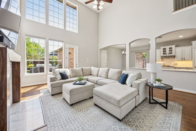 9892 Ranchero Dr, Frisco, TX 75033 - living room featuring arched walkways, baseboards, a ceiling fan, and a wealth of natural light