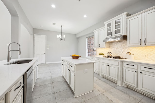 9892 Ranchero Dr, Frisco, TX 75033 - kitchen with a center island, a sink, appliances with stainless steel finishes, under cabinet range hood, and backsplash
