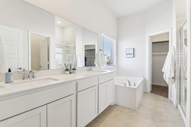 13412 Cortes De Pallas Dr, Little Elm, TX 75068 - bathroom featuring a shower stall, a walk in closet, tile patterned flooring, double vanity, and a garden tub