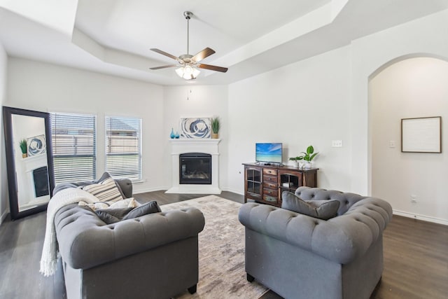 13412 Cortes De Pallas Dr, Little Elm, TX 75068 - living area with a raised ceiling, arched walkways, a glass covered fireplace, and wood finished floors