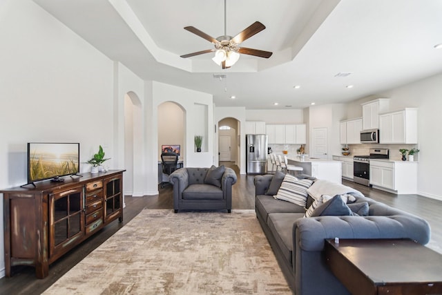 13412 Cortes De Pallas Dr, Little Elm, TX 75068 - living room featuring arched walkways, ceiling fan, wood finished floors, and a raised ceiling