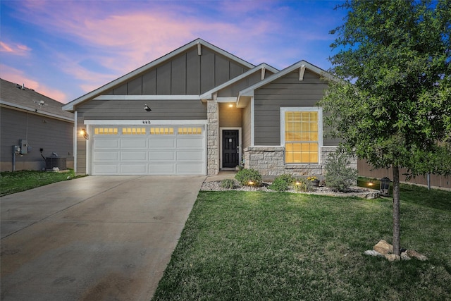 view of front of property featuring board and batten siding, cooling unit, a lawn, an attached garage, and driveway