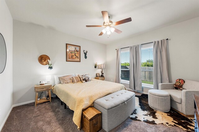 carpeted bedroom with ceiling fan and baseboards