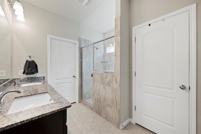 full bath featuring a sink, a shower stall, and tile patterned flooring