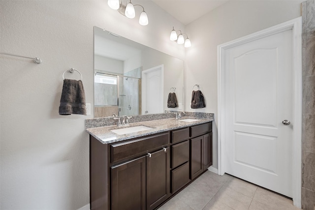 full bath with a shower stall, tile patterned floors, double vanity, and a sink