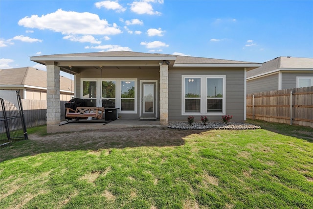 back of house with a yard, a fenced backyard, and a patio