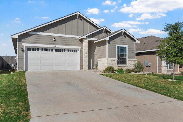 craftsman-style house featuring driveway, board and batten siding, stone siding, an attached garage, and a front yard