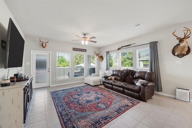 living room with light tile patterned flooring, ceiling fan, baseboards, and visible vents