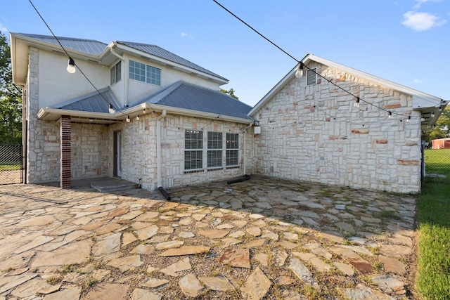 1028 Rs County Road 4261, Emory, TX 75440 - back of house featuring a patio area, fence, stone siding, and metal roof