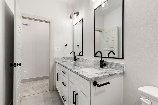 5703 Barkridge Dr, Granbury, TX 76048 - full bathroom featuring a sink, toilet, double vanity, and baseboards